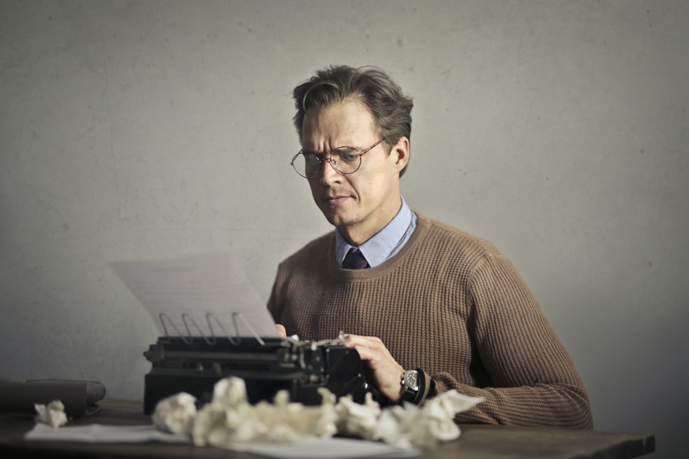 Mann schreibt konzentriert auf Schreibmaschine